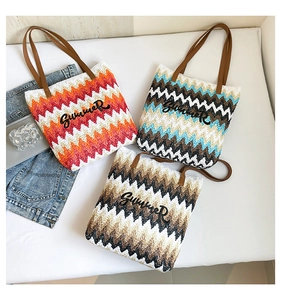 Detail of colorful zigzag woven straw tote bags with Summer embroidery and leather handles