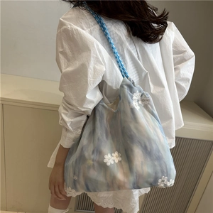 Chic tie-dye tote bag with delicate white lace flower accents and braided rope straps