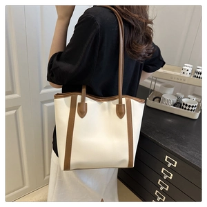 Detail of minimalist cream PU tote bag with brown leather contrast and large capacity