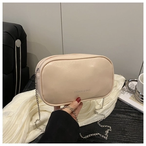 Détail d'un sac bandoulière en similicuir crème avec chaîne argentée et texte imprimé
