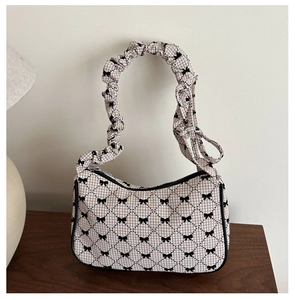 Detail of pleated cloud handle and beige checkered pattern with black bow prints