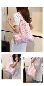 Pink bubble textured tote bag with black bow print showing shoulder and hand-carry styles