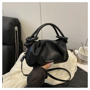 Détail d'un sac froncé noir avec poignées et logo Ben Sherman imprimé sur le cuir