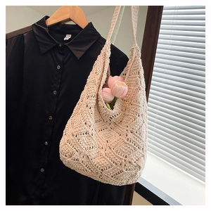 Close-up of cream crochet shoulder bag with intricate hollow floral knit patterns