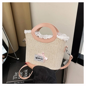 Détail d'un sac seau tressé avec bordure en dentelle blanche et nœud rose élégant