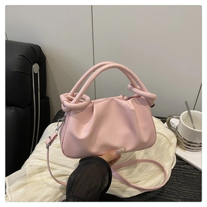 Détail du sac à main plissé rose avec poignée nouée et texture en cuir souple