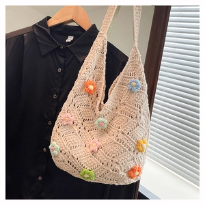 Detail of handmade beige crochet tote bag with colorful 3D floral knit patterns