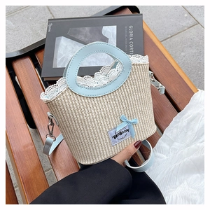 Detailed straw bucket bag with blue leather handle and romantic lace lining trim