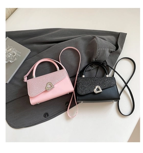 Gros plan de mini sacs à bandoulière rose et noir avec rabats à paillettes et cœur