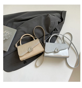 Détail de mini sacs à bandoulière pailletés avec fermoirs cœur en argent et doré