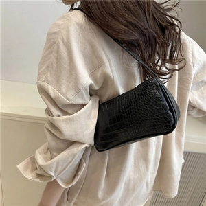 Classic black crocodile pattern baguette bag worn on shoulder for retro fashion look