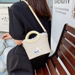 Chic beige straw bucket bag with white lace trim and bow for summer fashion styling