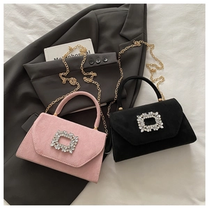 Dettaglio di borse in camoscio rosa e nero con fibbie di strass e catene dorate