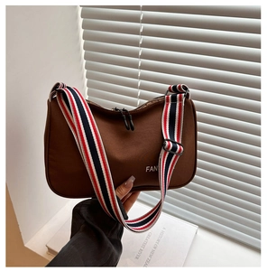 Détail du sac bandoulière marron avec sangle sport rayée rouge, blanc et bleu