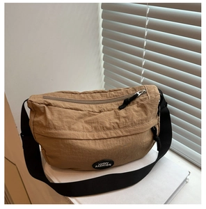 Detail of khaki nylon tote bag showing soft pleated texture and Lucky Fashion badge
