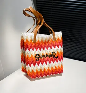 Detail van zomerse strooien tas met oranje golfpatroon en Summer-borduurwerk