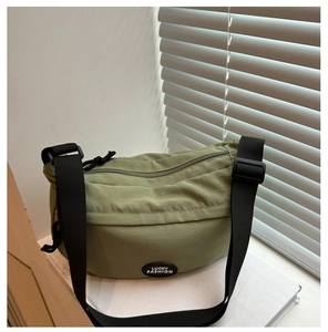Detail of army green nylon crossbody bag with Lucky Fashion logo on white background