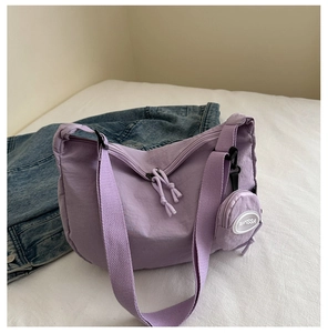 Detail of purple nylon tote bag with dual zippers and a small round detachable coin pouch