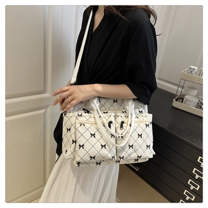 Detail view of cream corduroy tote bag with bow print and multiple zipper pockets