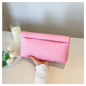 Close-up of pink woven texture on a large capacity envelope clutch held by hand