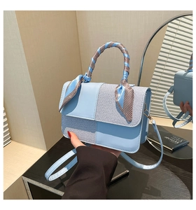Detail of light blue PU leather bag with silk scarf handle and textured weave pattern