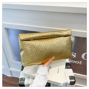 Detail of the woven texture and golden metallic finish on the elegant envelope clutch bag