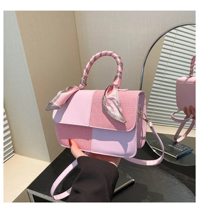 Detail of pink patchwork crossbody bag featuring silk scarf handle and smooth texture