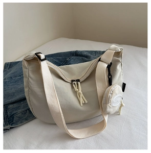 Detail view of the cream crescent nylon tote bag with round coin purse and double zippers
