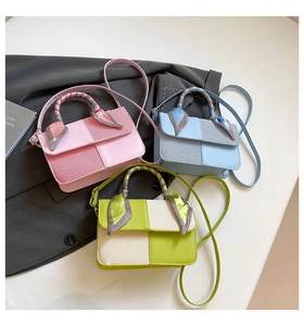 Detail of color-block square handbags with decorative silk scarves and shoulder straps