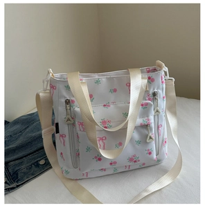 Detailed close-up of floral canvas tote bag showing side zipper and bow pattern