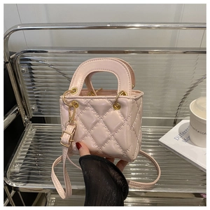 Detail of pink quilted micro bag with round handle and gold hardware and shoulder strap