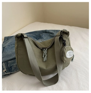 Detail of army green nylon crescent bag with wide strap and matching round coin purse