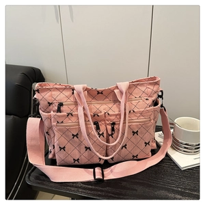 Close-up of pink corduroy tote bag featuring black bow prints and functional pockets