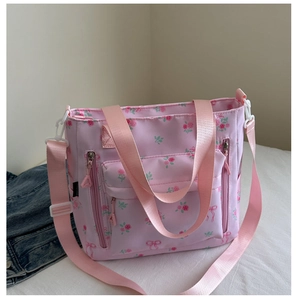 Close-up of pink floral tote bag showing nylon texture and adjustable shoulder strap