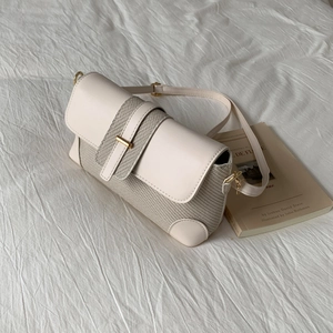Détail du sac à main beige clair avec tissu tissé et boucle en métal doré chic