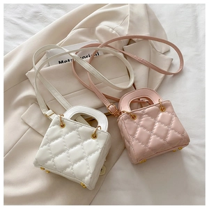Detailed view of quilted leather mini bags in white and pink with gold hardware