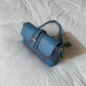 Détails du sac à bandoulière bleu avec cuir lisse et textures de tissu tissé