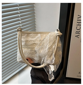Detailed close-up of cream lace crossbody bag with delicate floral texture and ribbons