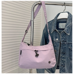 Detail view of purple nylon shoulder bag with adjustable strap and drawstring design