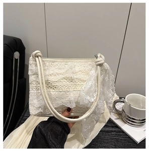 Close-up of elegant white lace ruffle handbag with intricate embroidery and rope handles