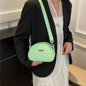 Light green nylon crescent crossbody bag with adjustable wide strap shown on model