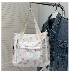 Floral canvas tote bag featuring pink rose patterns and multiple zipper pockets