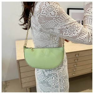 Detailansicht der hellgrünen Leder-Handtasche mit goldener Kette und feiner Narbenstruktur