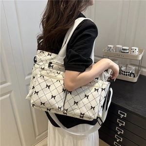 Corduroy tote bag with bow print and diamond stitching shown on a model's shoulder
