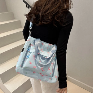 Light blue floral tote bag with pink roses and red bows, perfect for casual commuting