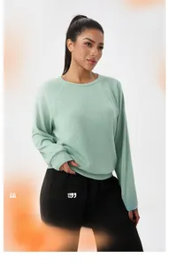 Détail du sweat-shirt vert menthe en maille gaufrée avec manches raglan et col rond