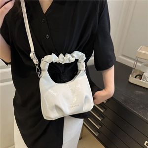 Fashionable white ruched handle crossbody bag with glossy finish and chain shoulder strap