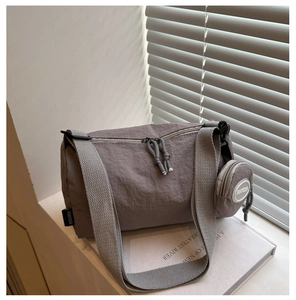 Detailansicht graue Nylon-Pillows-Tasche mit breitem Gurt und Mini-Münzgeldbörse
