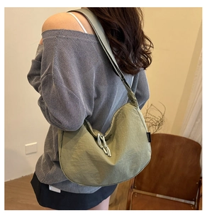 Close-up of olive green nylon crescent bag with FANYISSA label and knot zipper detail