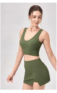 Détail de la texture du haut de yoga côtelé vert foncé et jupe fendue latérale
